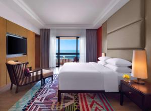 a bedroom with a large white bed and a chair at Hyatt Regency Kuantan Resort in Kuantan