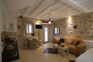 salon z kanapą i kamienną ścianą w obiekcie NJ Corfu Liston Apartments w Korfu