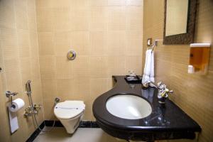 塞恩Hotel Tip Top Plaza的一间带黑色水槽和卫生间的浴室