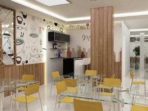 a dining room with a glass table and yellow chairs at Hotel Silver Leaf, Noida in Noida