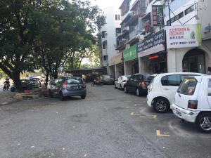 ein Parkplatz mit Autos vor den Gebäuden in der Unterkunft Macallum Budget Muslim Homestay in George Town