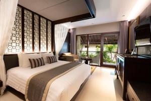 沙努尔Puri Santrian Beach Resort And Spa的卧室里有一张白色的大床和一台电视