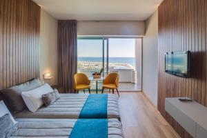 a hotel room with a bed and a view of the ocean at Sun Hall Hotel in Larnaka