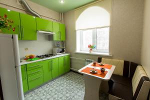 ヤロスラヴリにあるКвартира в центре Ярославля_Харитонова 3の小さなキッチン(緑のキャビネット、テーブル付)