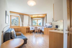 a kitchen and living room with a couch and a table at Hotel Kranebitt B&B in Bressanone