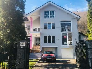 a white house with a car parked in front of it at Luxury Modern Apartments in Baia Mare