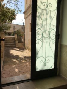 una porta aperta con cancello in un edificio di Giardini 82 B&B a Gravina in Puglia