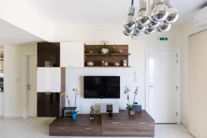 a living room with a tv and a wooden table at Groovy & Cozy APT with Private Seaview Rooftop Terrace in Rhodes Town