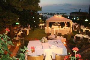 um restaurante com mesas brancas e um guarda-chuva branco em B&B Villa Delle Rondini em Vibo Marina