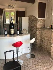 uma cozinha com um bar com um banco vermelho e garrafas de vinho em B&B Villa Delle Rondini em Vibo Marina