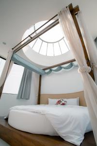 a bedroom with a canopy bed with a window at Love Tour in Magong