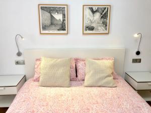 1 dormitorio con 1 cama rosa y 2 lámparas en Gros Beach Apartment, en San Sebastián