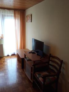 a room with a desk with a television and a chair at Apartma pod Rožco in Jesenice