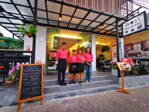 a group of people standing in front of a restaurant at iNest Poshtel in Kata Beach