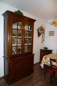 a large wooden cabinet with glass doors in a room at Dolomitissime Holiday Homes Marmolada in Rocca Pietore