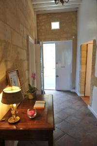 a room with a table with a lamp and a door at logis-des-cordeliers in Saint-Émilion
