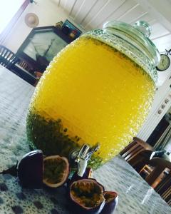 a large glass jar of orange juice on a table at Relais Des Gouverneurs in Salazie