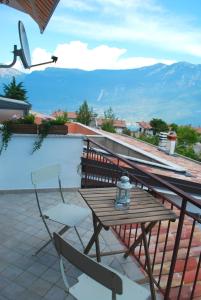 een tafel en stoelen op een balkon met uitzicht op de bergen bij Appartamento Bijoux - Rebomaholidays in Tignale