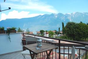 een tafel op een balkon met uitzicht op de bergen bij Appartamento Bijoux - Rebomaholidays in Tignale
