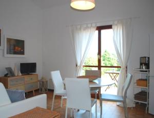 een woonkamer met een tafel en stoelen en een raam bij Appartamento Bijoux - Rebomaholidays in Tignale