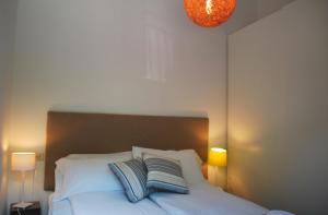 een slaapkamer met een wit bed met 2 kussens bij Appartamento Bijoux - Rebomaholidays in Tignale