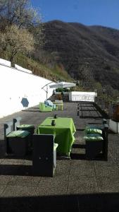 un tavolo e sedie verdi con una montagna sullo sfondo di B&B Il Santo Pellegrino ad Adrara San Rocco