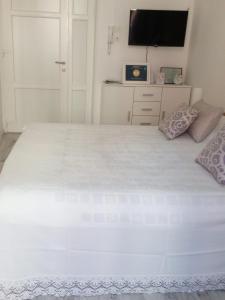 a bedroom with a large white bed with a flat screen tv at Studio in Pula center in Pula