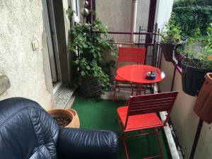 un patio con 2 sillas y una mesa roja en Mitten in Leipzig Wohnung 1, en Leipzig