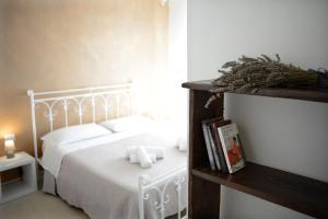 a bedroom with a white bed with white pillows at B&B Alghero 82 in Alghero