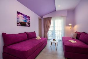 a purple living room with a couch and a table at GiRene Apartments in Limenaria