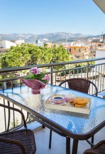 een tafel met een dienblad met eten op een balkon bij GiRene Apartments in Limenaria