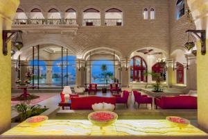 a lobby of a hotel with red chairs and tables at Kempinski Hotel Soma Bay in Hurghada