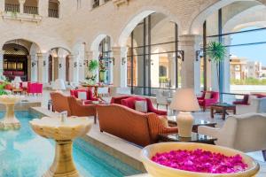 a hotel lobby with a pool and tables and chairs at Kempinski Hotel Soma Bay in Hurghada