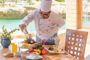 a chef preparing food on top of a table at Kempinski Hotel Soma Bay in Hurghada