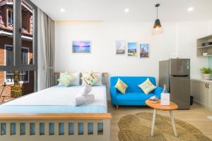 a bedroom with a bed and a blue couch at MayMay Da Lat Apartments in Da Lat