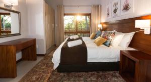 a bedroom with a large bed with a wooden headboard at Kruger Park Lodge Unit No 612 with private splash Pool in Hazyview +38 photos