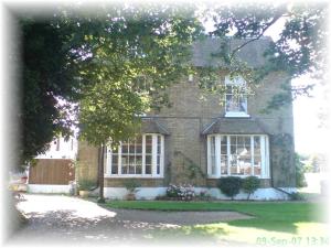 una casa de ladrillo con ventanas blancas y una valla en Glebe House, en Deal