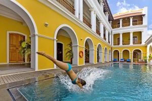 a woman in a swimming pool in a building at Palais De Mahe - CGH Earth in Puducherry