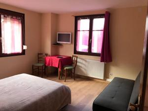 - une chambre avec un lit, une table et des fenêtres dans l'établissement Auberge Restaurant La Roseraie, à Grandrupt