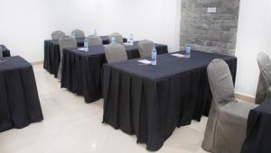 eine Reihe von Tischen mit schwarzen Tischdecken und Stühlen in der Unterkunft Sleep Inn Hotel - Kariakoo in Daressalam