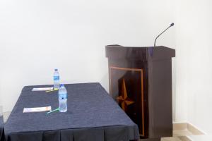 een podium en een tafel met een fles water erop bij Sleep Inn Hotel - Kariakoo in Dar es Salaam