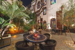 un patio con mesa y sillas en un edificio en Riad Le Calife, en Fez