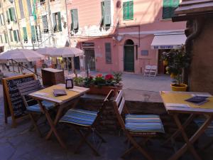duas mesas e cadeiras com guarda-sóis numa rua em Affittacamere Rollando em Vernazza