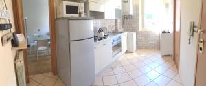 uma cozinha com um frigorífico branco e um lavatório em Casa Casò Guest House em Bolonha