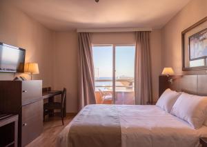 a hotel room with a bed and a large window at Hotel Cristina in Los Alcázares