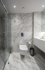 a marble bathroom with a toilet and a shower at Sun Hall Hotel in Larnaca