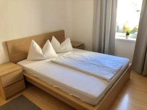 1 dormitorio con 1 cama con sábanas blancas y ventana en Forsthof Next Door, en Sierning