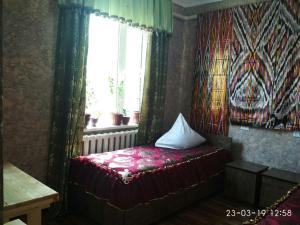 a small bedroom with a bed with a window at Mubina Khiva B&B in Khiva