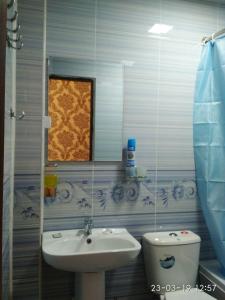 a bathroom with a sink and a toilet and a mirror at Mubina Khiva B&B in Khiva