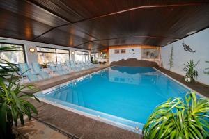 a large swimming pool with chairs in a house at Hotel Madatsch in Trafoi